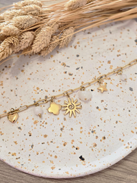 Bracelet doré acier inoxydable breloque soleil et perles blanches