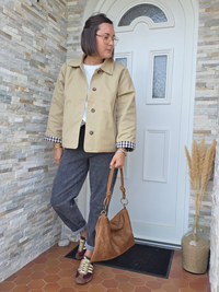 Trench court femme beige oversize porté avec jean gris et baskets