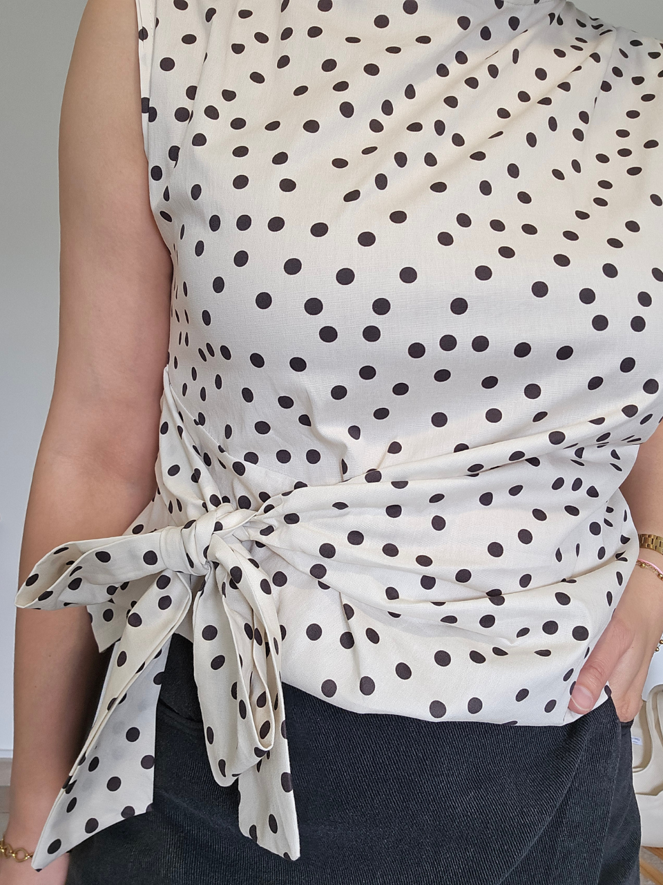 Haut chic blanc à pois noirs avec nœud latéral