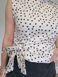 Haut chic blanc à pois noirs avec nœud latéral
